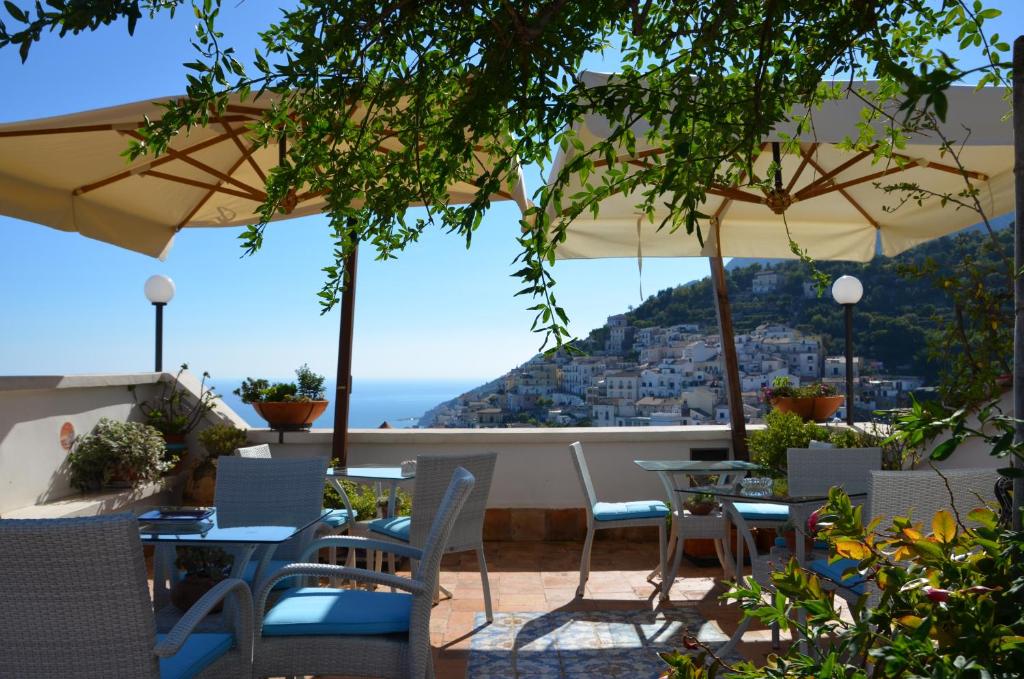 un patio con mesas y sillas y vistas al océano en La Soffitta Sul Mare, en Vietri