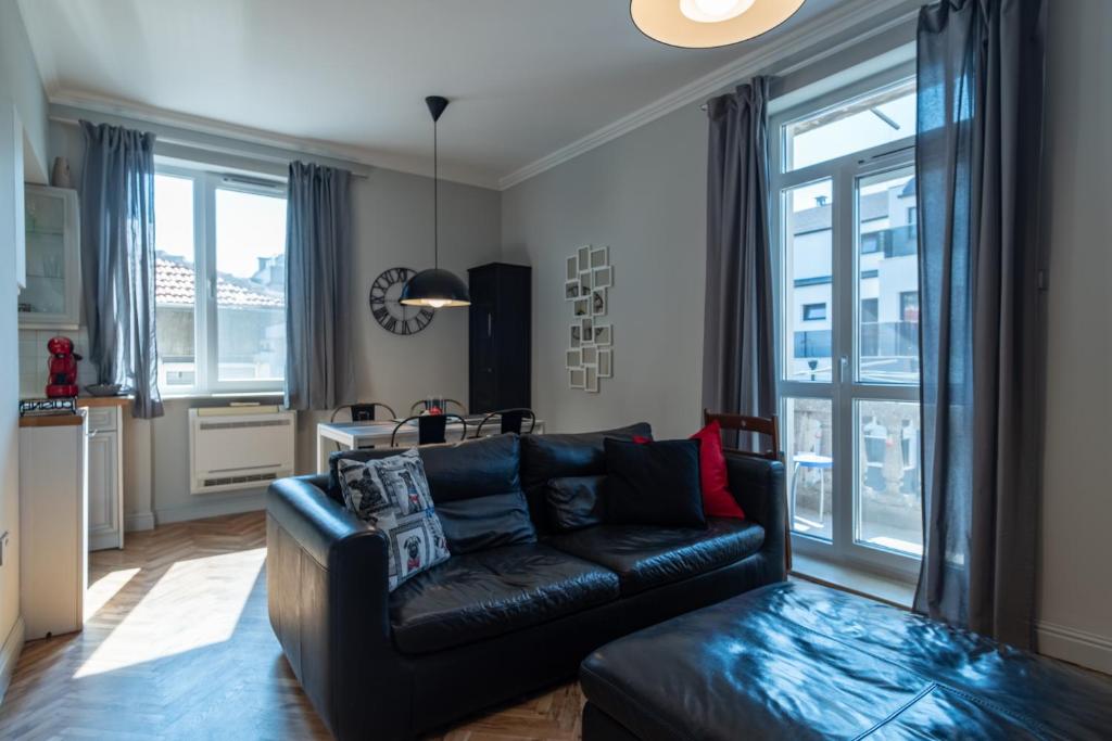 uma sala de estar com um sofá de couro preto em Midnight Blue em Burgas