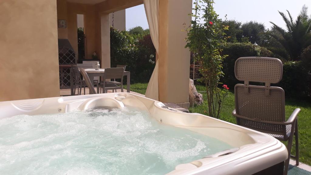 a jacuzzi tub in a yard with a table and chairs at Il Giardino di Laura - Sirmione in Sirmione