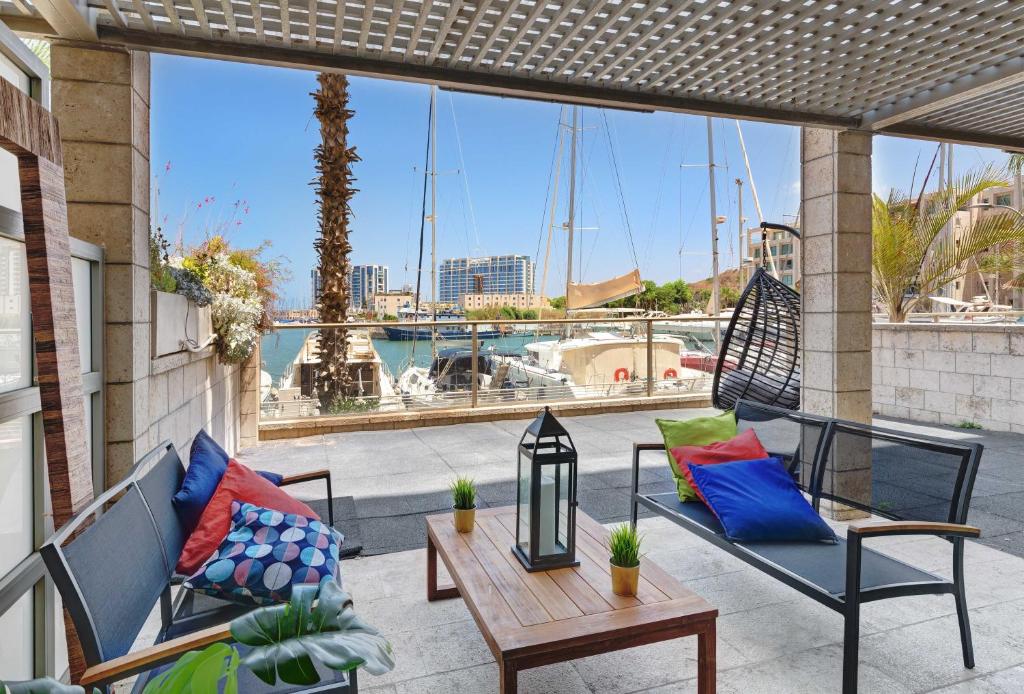 patio z krzesłami i stołem oraz widokiem na port w obiekcie Lagoon Water Front Suite w mieście Herzliya