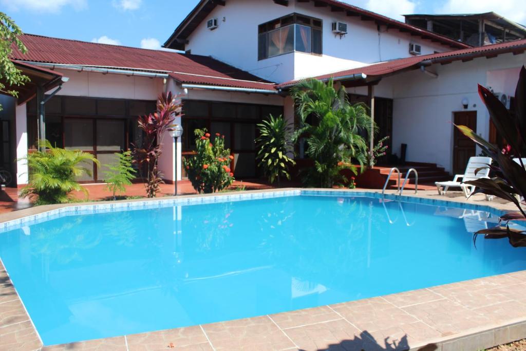 a swimming pool in front of a house at Posada Cumpanama in Yurimaguas