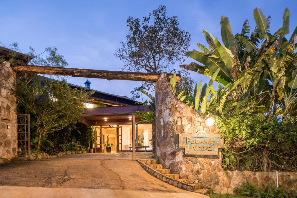 a entrance to a hotel with a stone wall at Pousada Maya in Alto Paraíso de Goiás