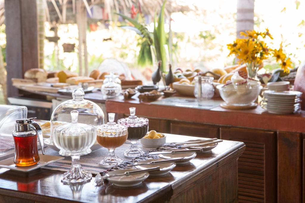 a table with plates and glasses and dishes on it at Pousada Maya in Alto Paraíso de Goiás