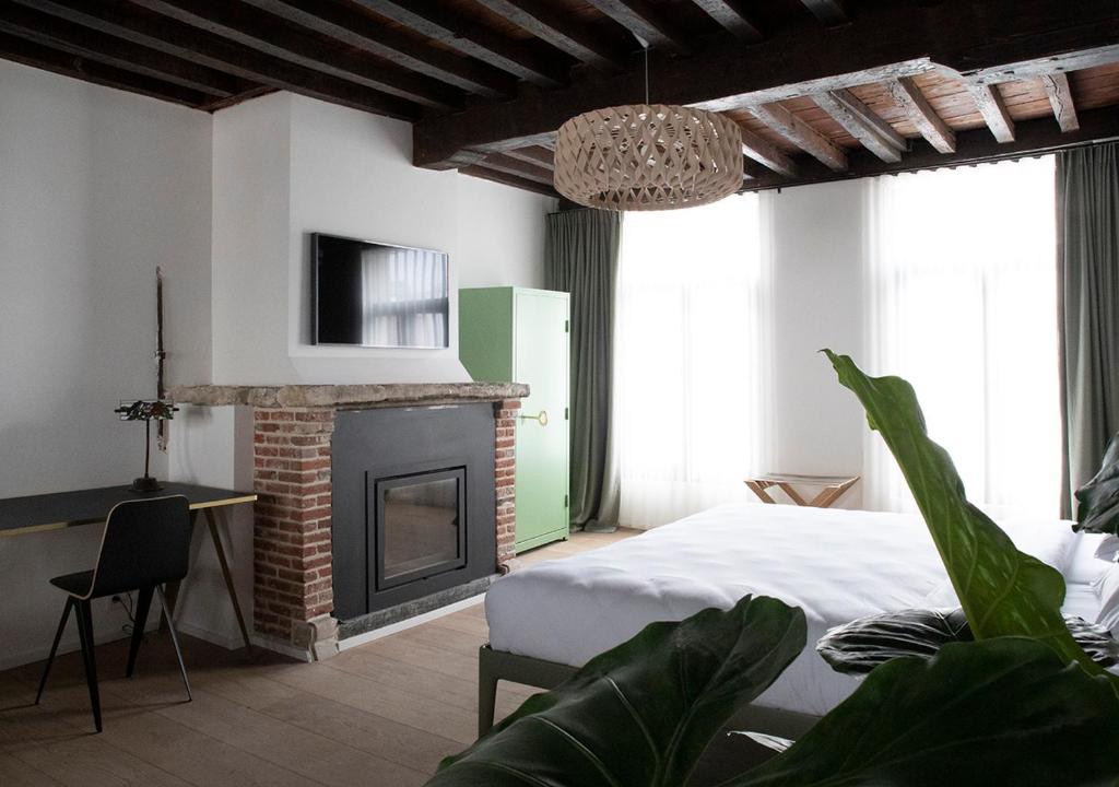 een slaapkamer met een bed en een open haard bij The Greenhouse in Antwerpen