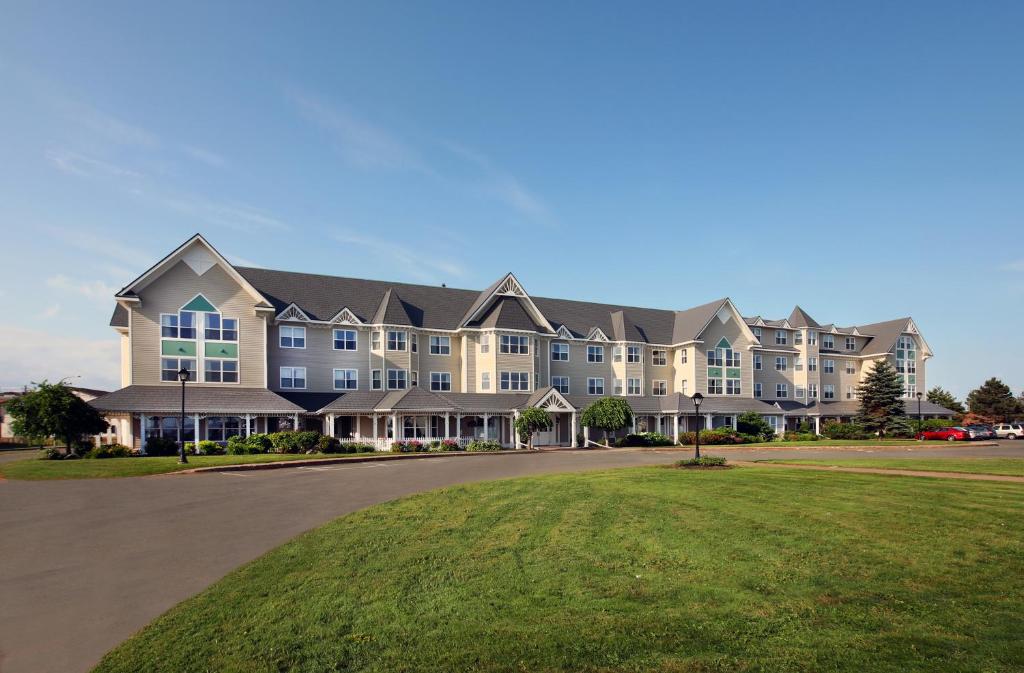 a large apartment building with a green lawn at The Loyalist Country Inn & Conference Centre in Summerside