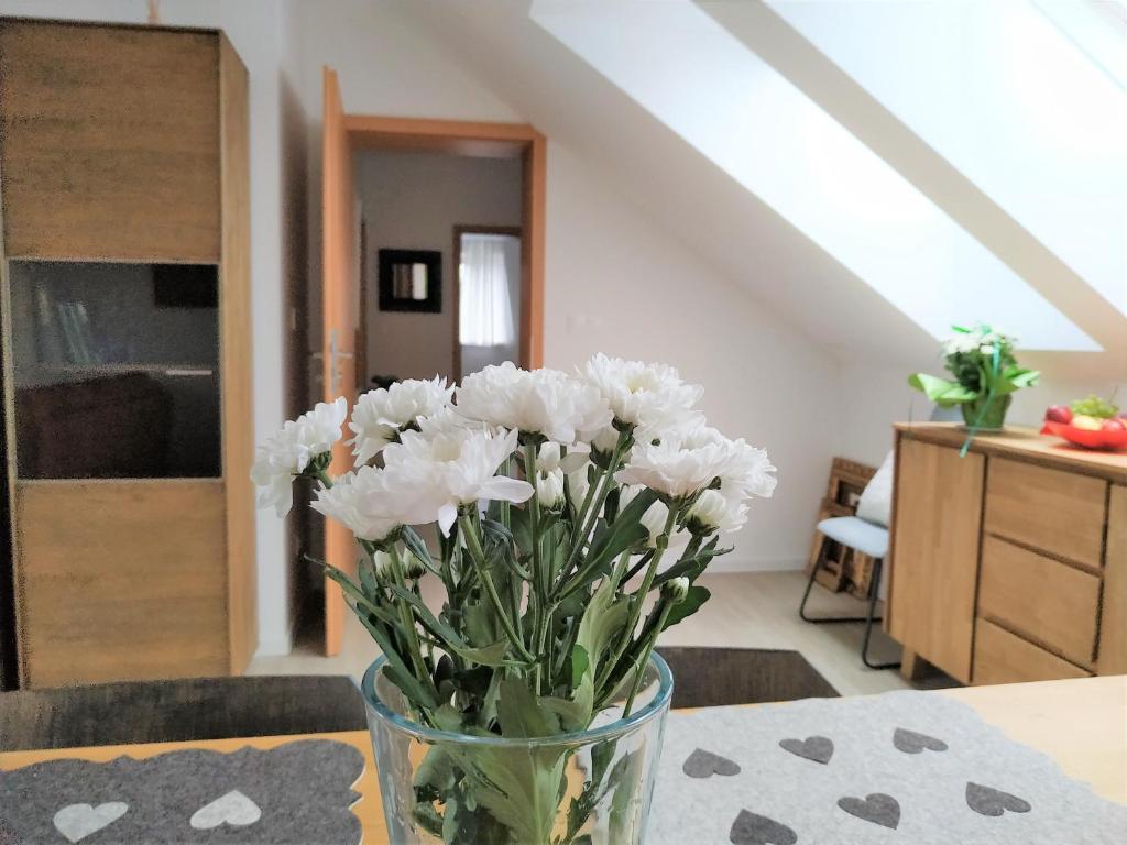a vase of white flowers sitting on a table at Bratislava design apartment in Bratislava