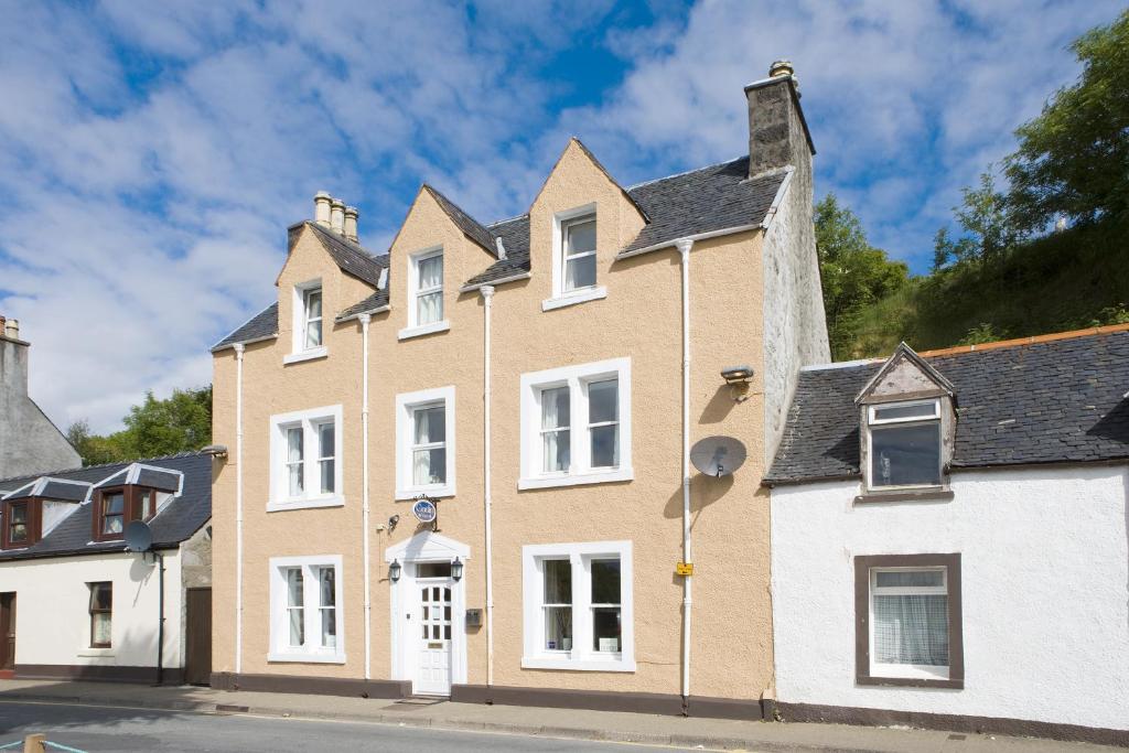 a large house with white windows on a street at Coolin View in Portree