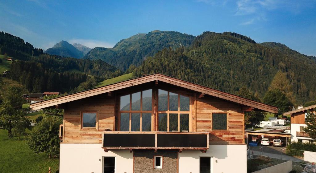 een houten huis met bergen op de achtergrond bij Alpin Penthouse Hollersbach in Hollersbach im Pinzgau