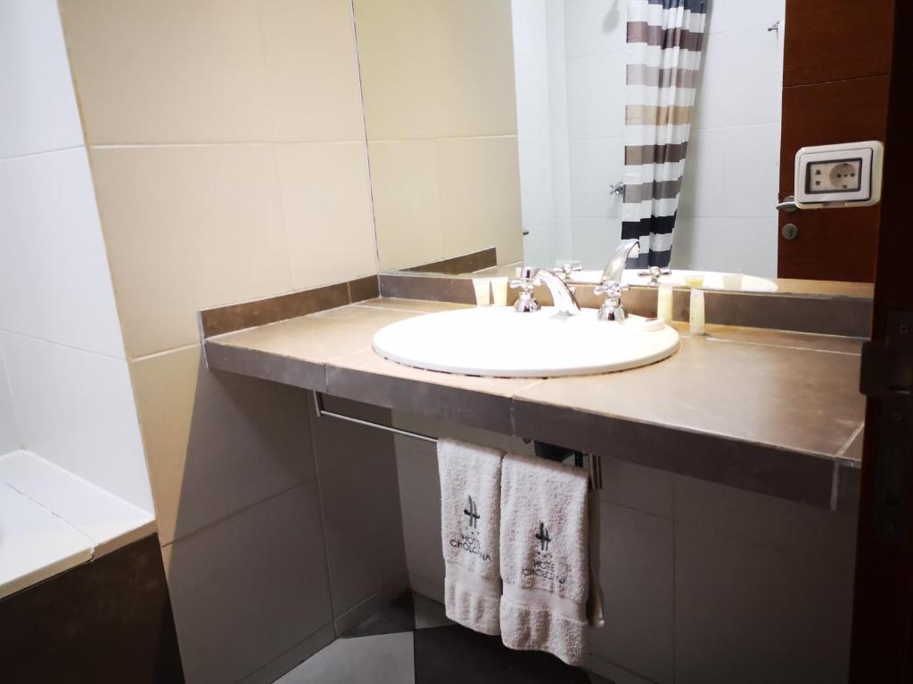 a bathroom with a white sink and a mirror at Hotel Cholcana in Lima