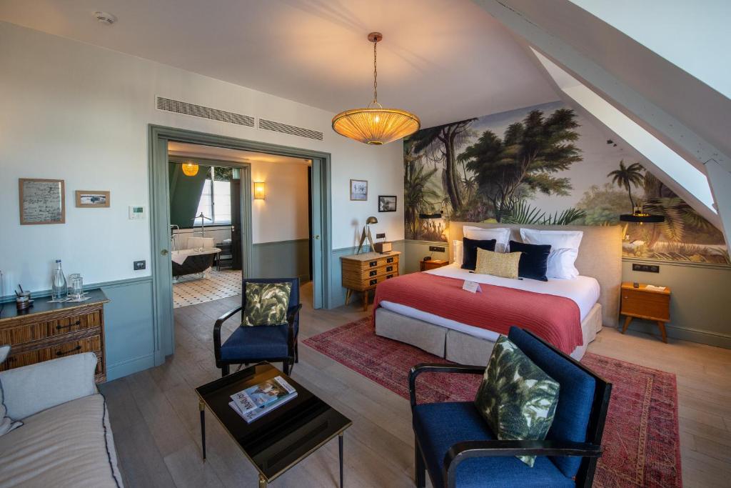 a bedroom with a bed and a living room at Le Nessay in Saint-Briac-sur-Mer