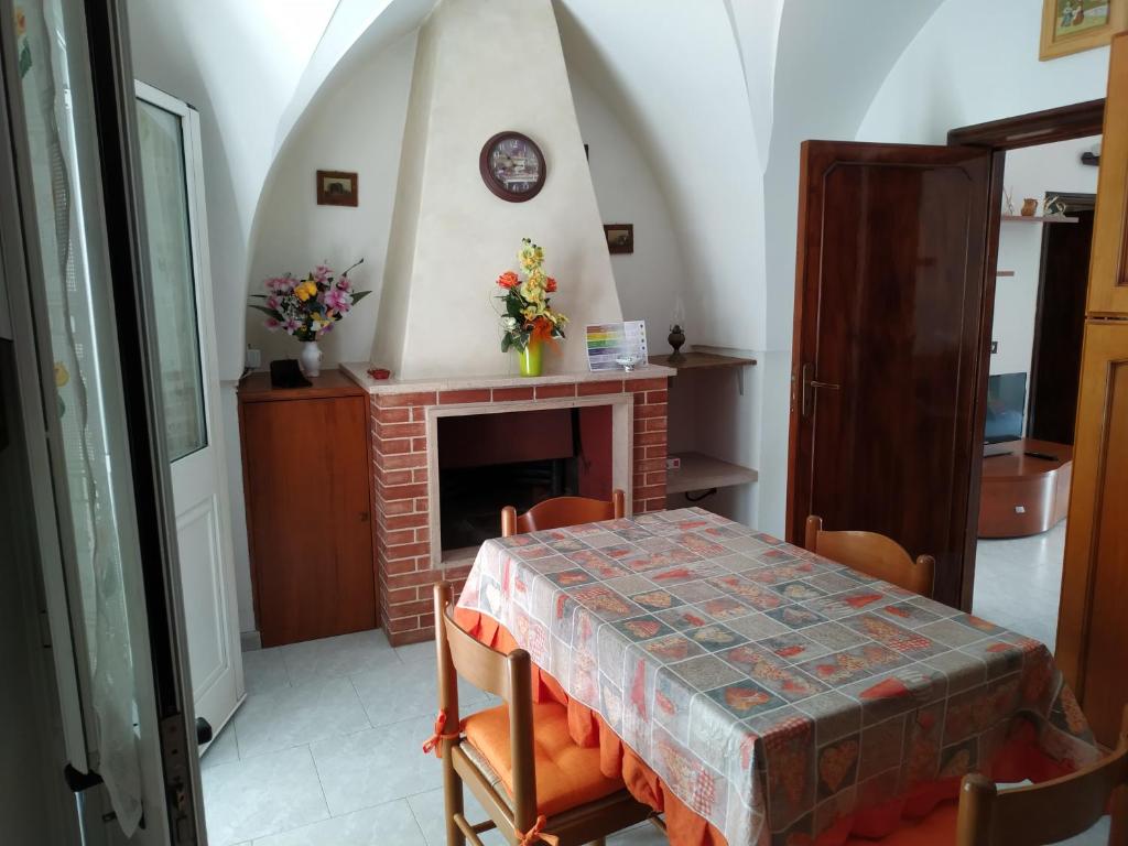 comedor con mesa y chimenea en Casa Sosò, en Maruggio
