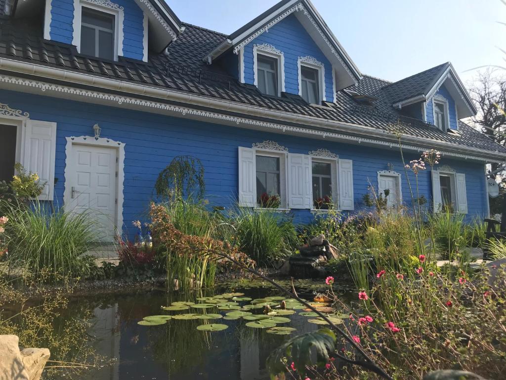 ビャウォヴィエジャにあるPensjonat Krainkaの池のある青い家