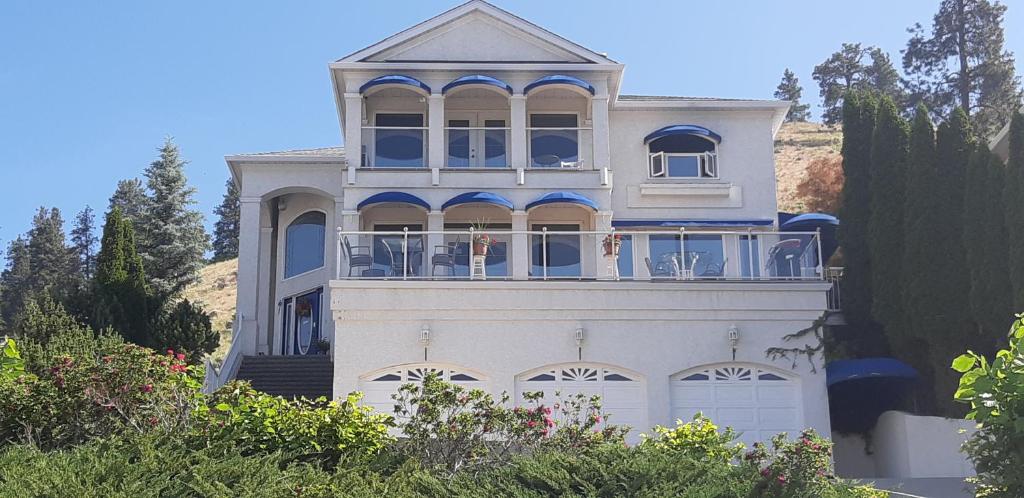 a large white house with a large window at Vacation Lake View House kelowna BNB in Kelowna