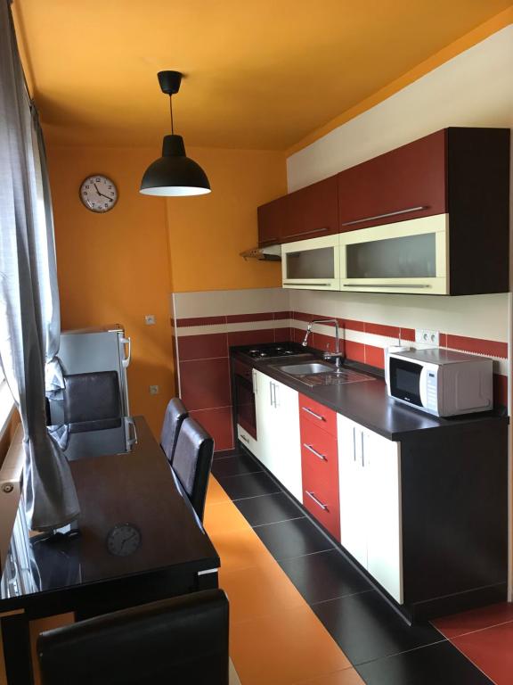 a kitchen with red and white cabinets and a table at Apartmán Hodruša-Hámre in Hodruša