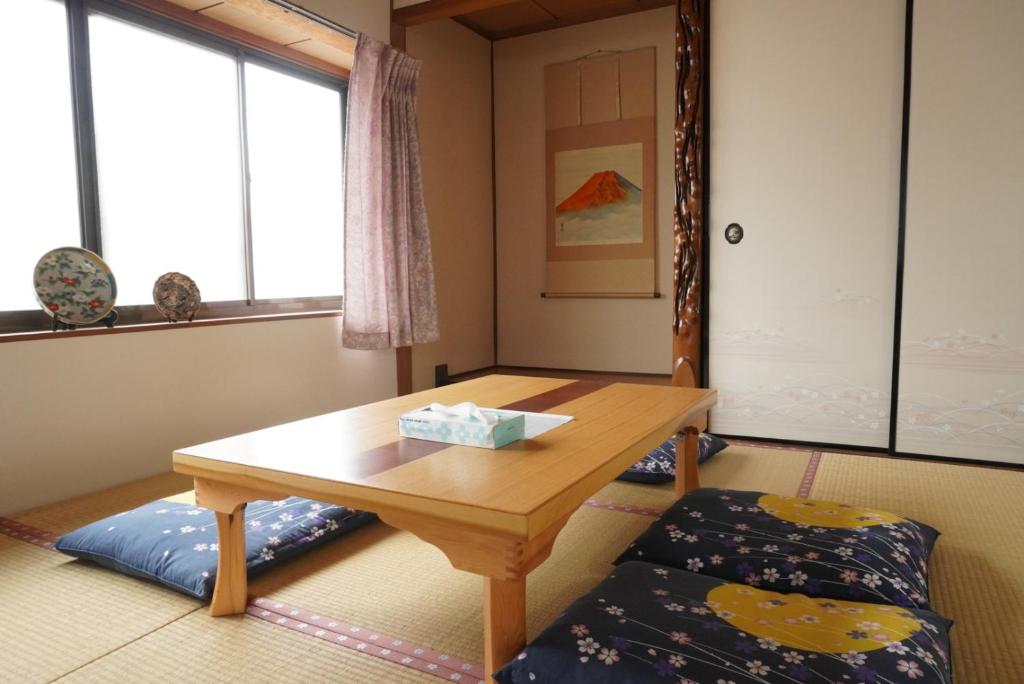 a room with a wooden table and a bench at Villa alive in Takekara