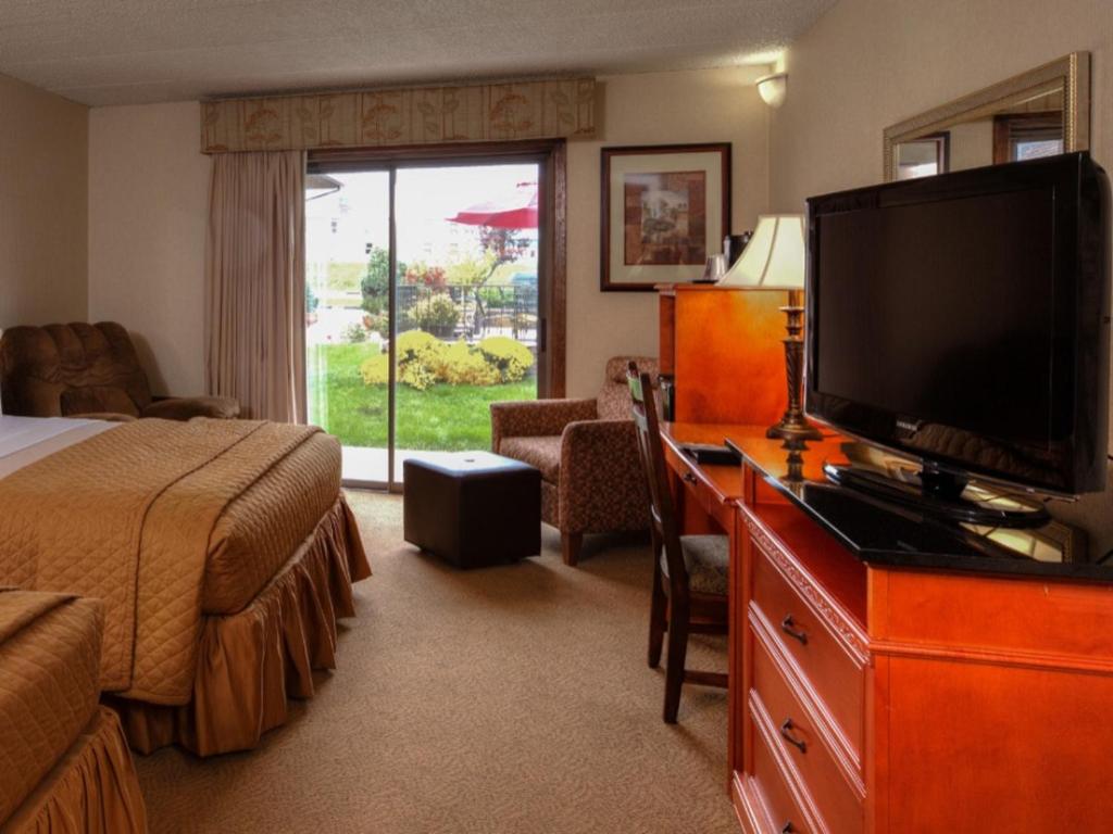 a hotel room with a bed and a flat screen tv at The Foothills Inn in Rapid City
