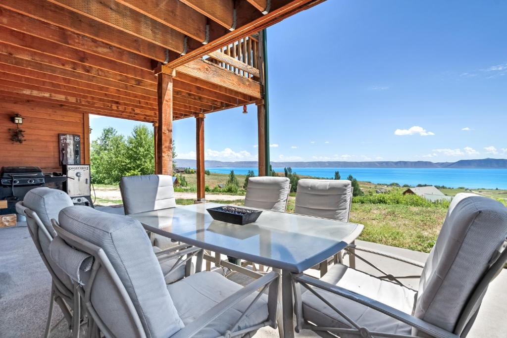 a table and chairs on a patio with a view of the water at Moose Mountain Retreat in Fish Haven