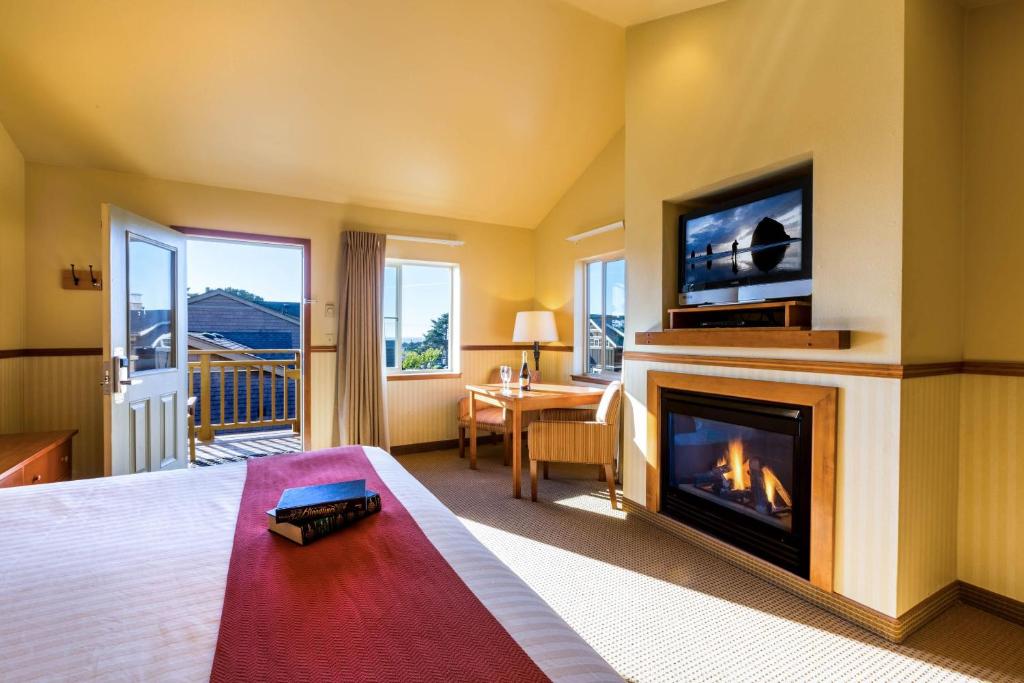 a hotel room with a fireplace and a television at Inn at Cannon Beach in Cannon Beach