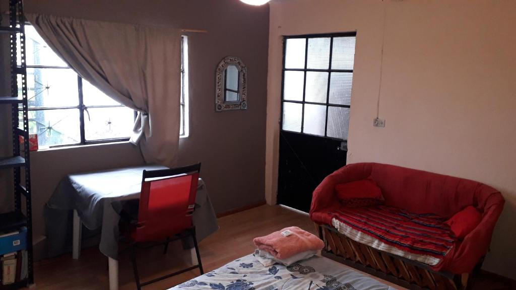 sala de estar con sofá rojo y mesa en El laberinto hospedaje en casa en Morelia