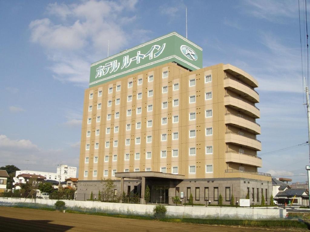 a large building with a sign on top of it at Hotel Route-Inn Shimodate in Chikusei