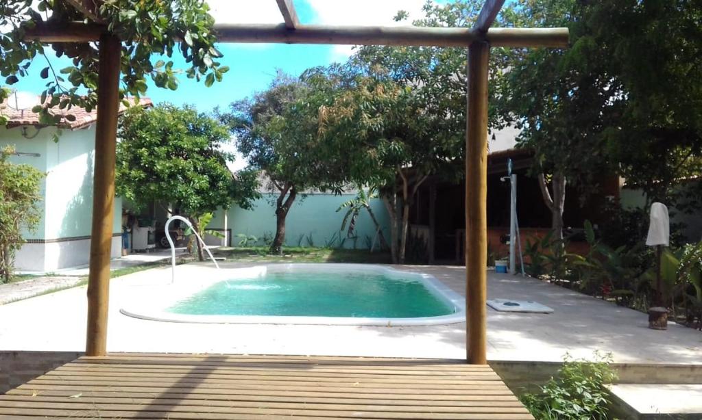 a swimming pool in a yard with an umbrella at Casa Fantástica in Guriri