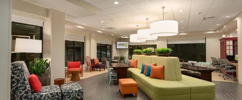 a waiting room with a couch and a table and chairs at Home2 Suites By Hilton Joplin, MO in Joplin