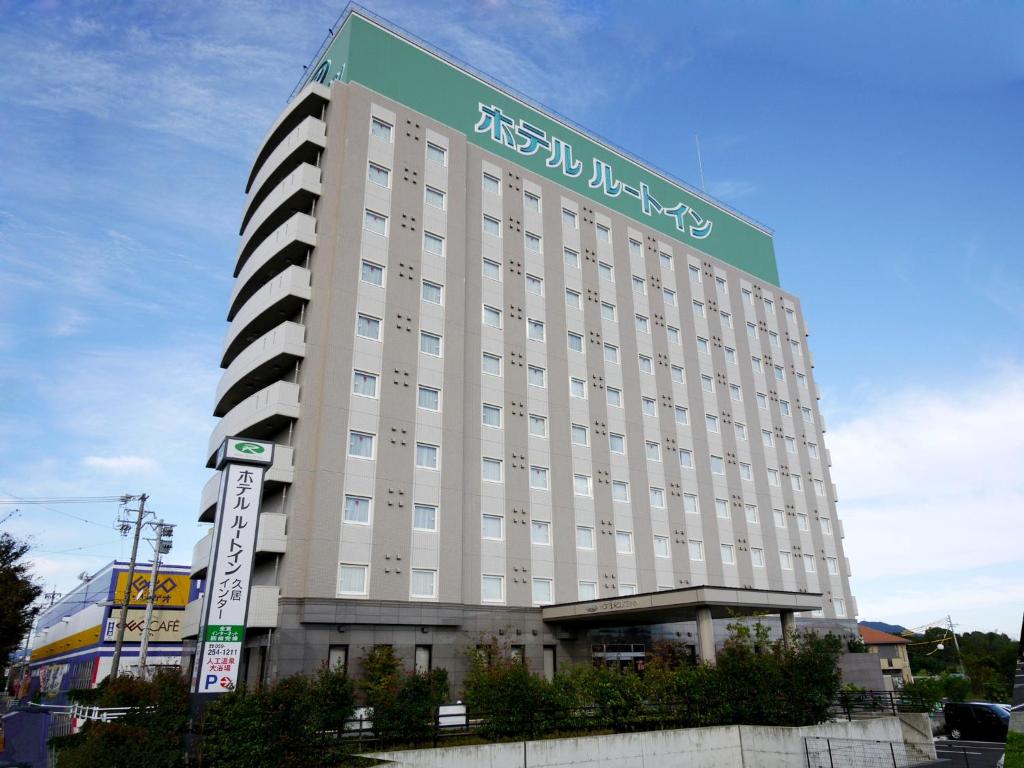 a large white building with a sign on it at Hotel Route-Inn Hisai Inter in Tsu