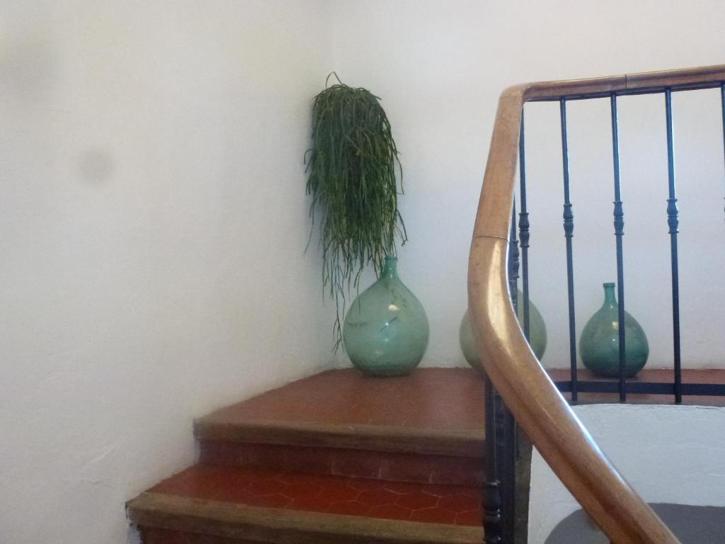 three green vases sitting on a staircase with a plant at L&#39;Auberge Espagnole - Bed &amp; Breakfast in Apt