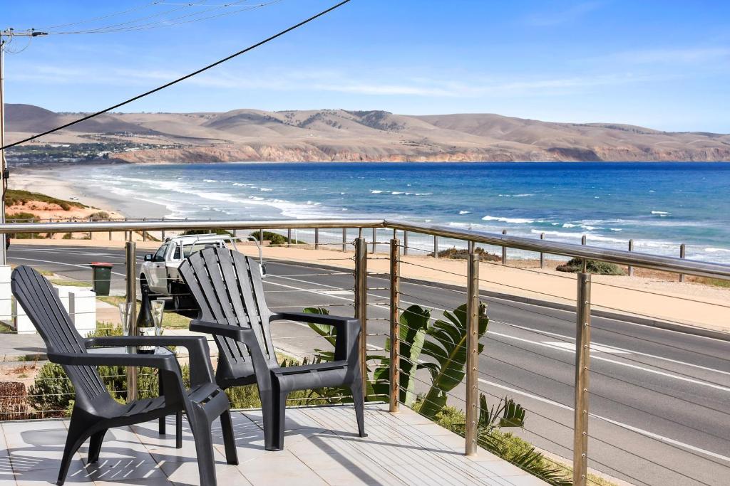 a balcony with two chairs and a view of the ocean at Esplanade Escape in Aldinga Beach