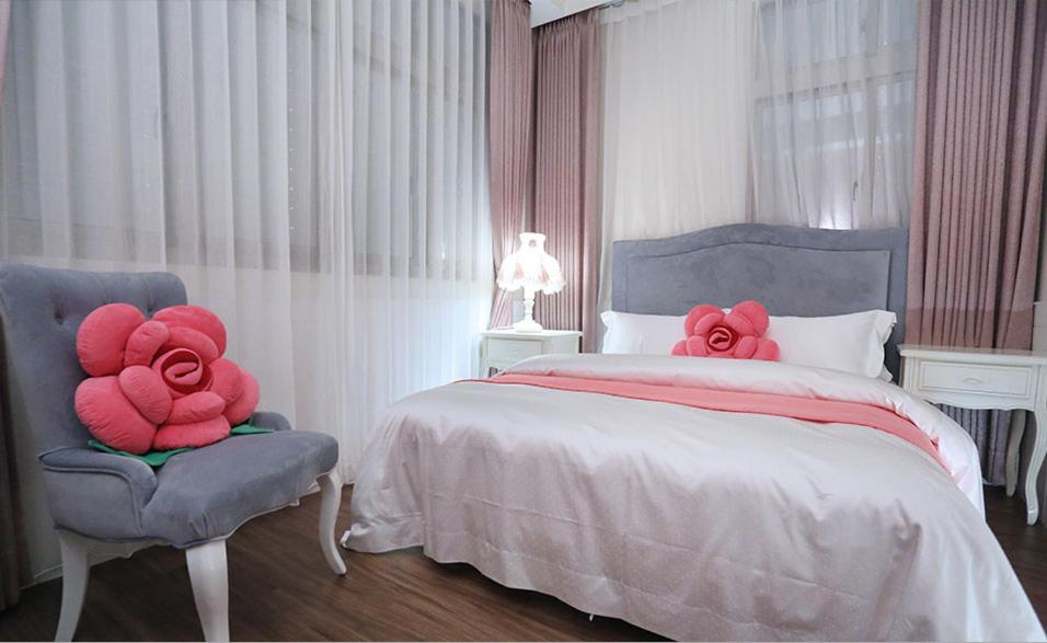 a bedroom with a bed with red stuffed roses on it at Campestral Garden in Jiaoxi