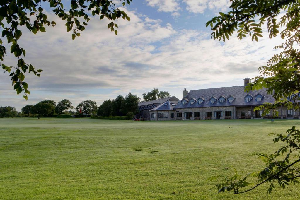 un gran campo de césped frente a un gran edificio en Garstang Country Hotel & Golf, Sure Hotel Collection, en Garstang