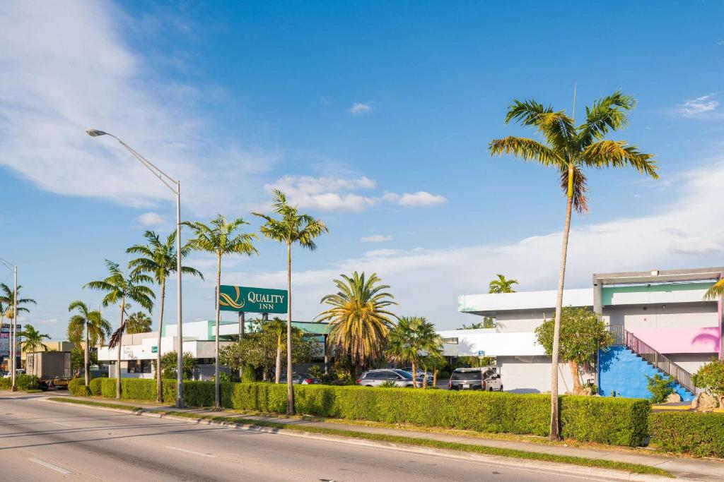 a street with palm trees in front of a building at Quality Inn Miami South in Kendall