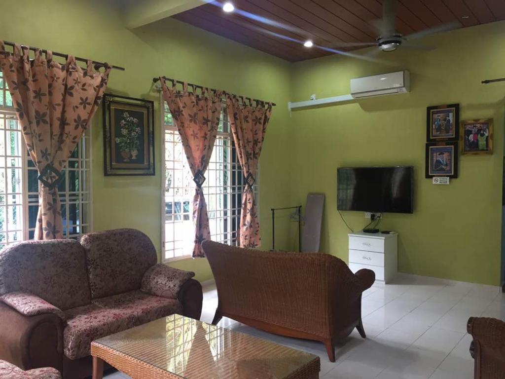 sala de estar con sofá y TV en Homestay Cikgu Sungai Batu Besi, en Bedung