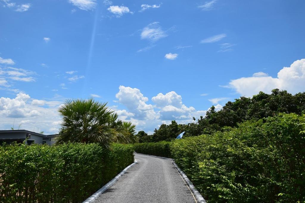 eine leere Straße mit Büschen und blauem Himmel in der Unterkunft SB Holiday Resort Chiang Mai in Chiang Mai