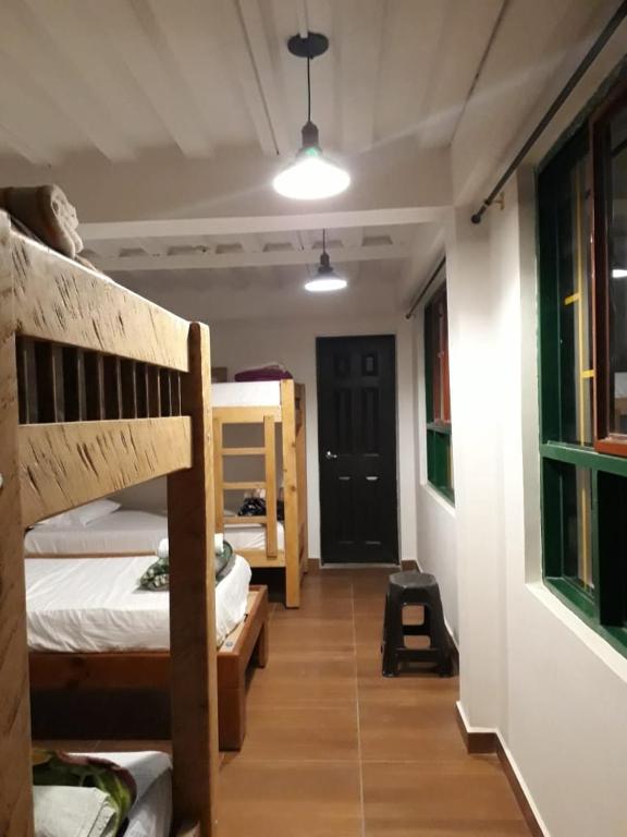 a room with two bunk beds and a hallway at Hostal Casa de Los Taitas in Salento