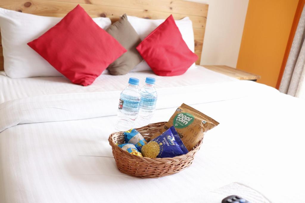een mand met eieren en flessen water op een bed bij Mapletree Inn in Bangalore