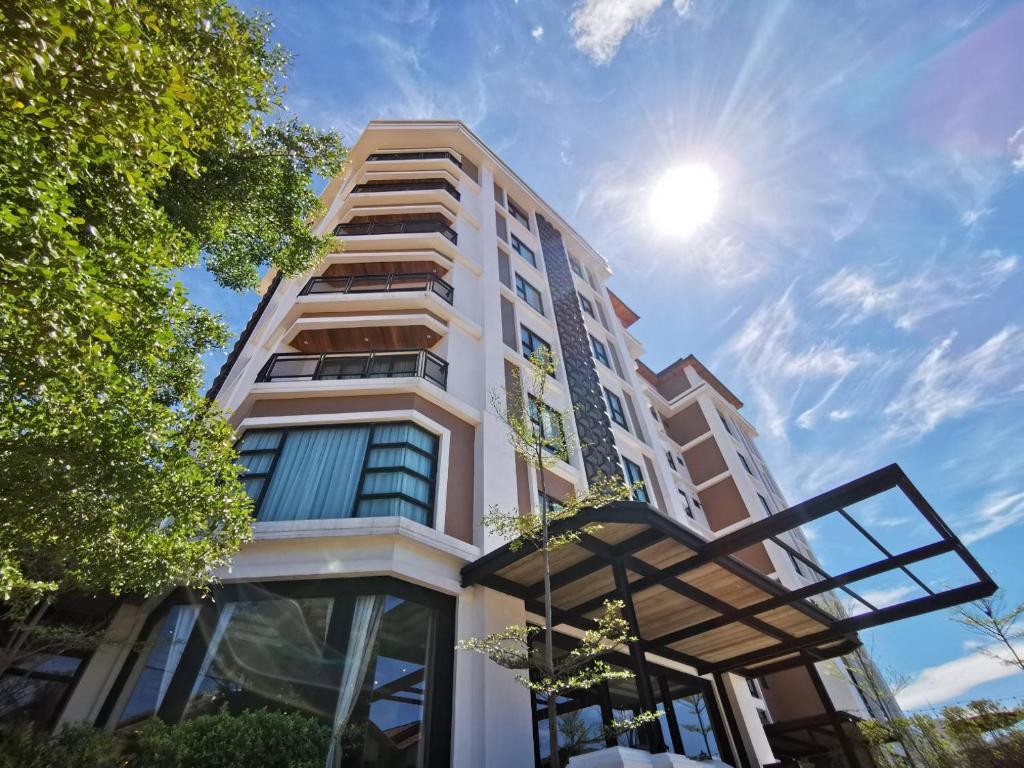 a tall building with the sun in the sky at S Park Design Hotel in Vientiane
