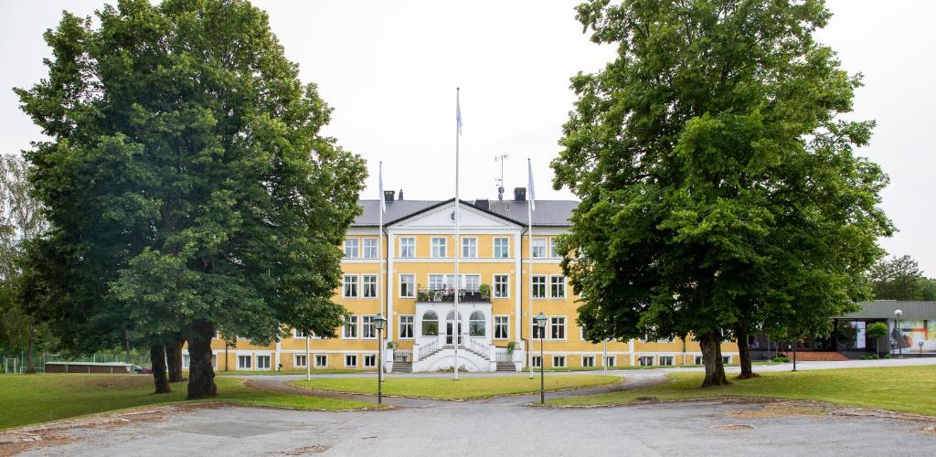 a large yellow building with trees in front of it at Tyringe Kurhotell in Tyringe