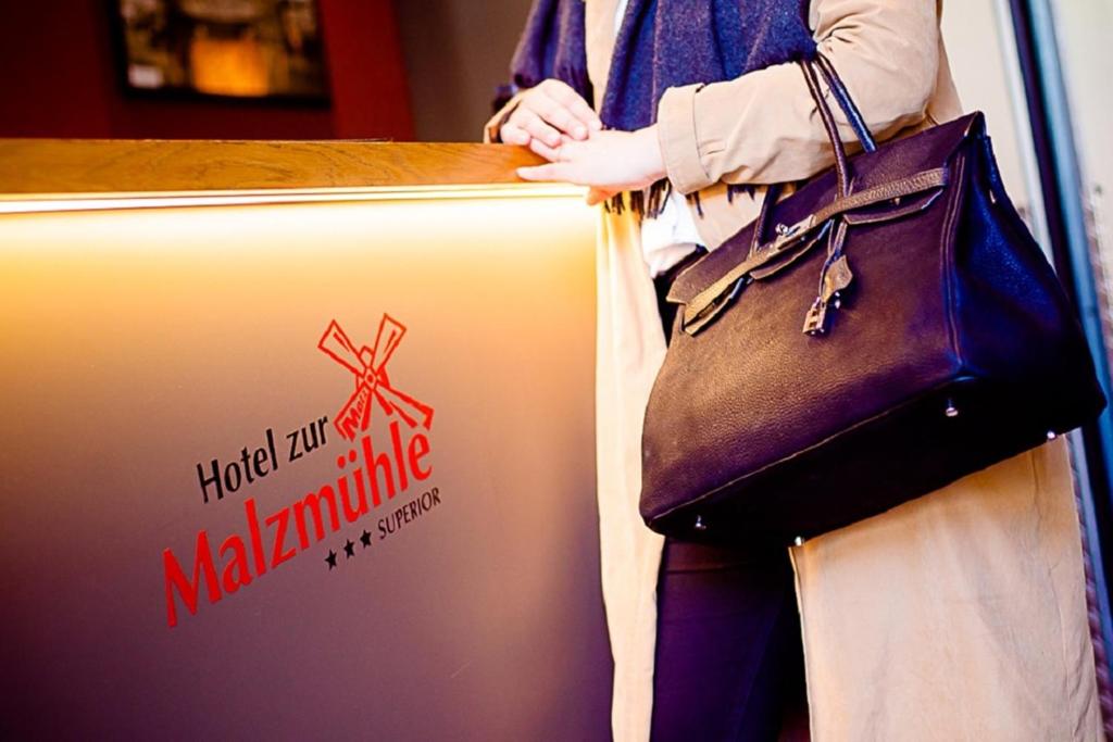 a woman standing next to a counter with a purse at Hotel zur Malzmühle in Cologne