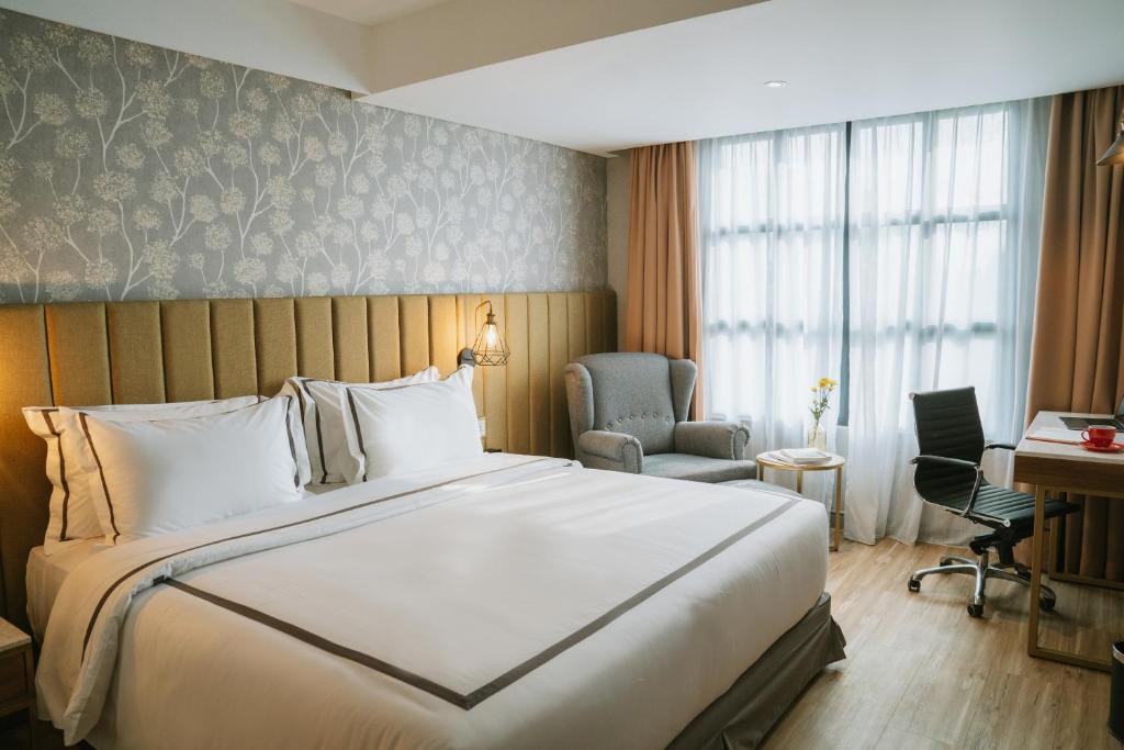 a hotel room with a large bed and a desk at Barito Mansion in Jakarta