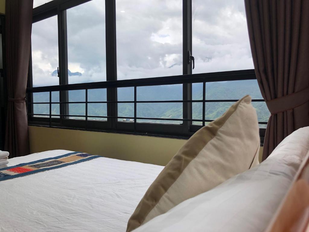Bett in einem Zimmer mit einem großen Fenster in der Unterkunft TUONG MAI HOTEL in Sa Pa