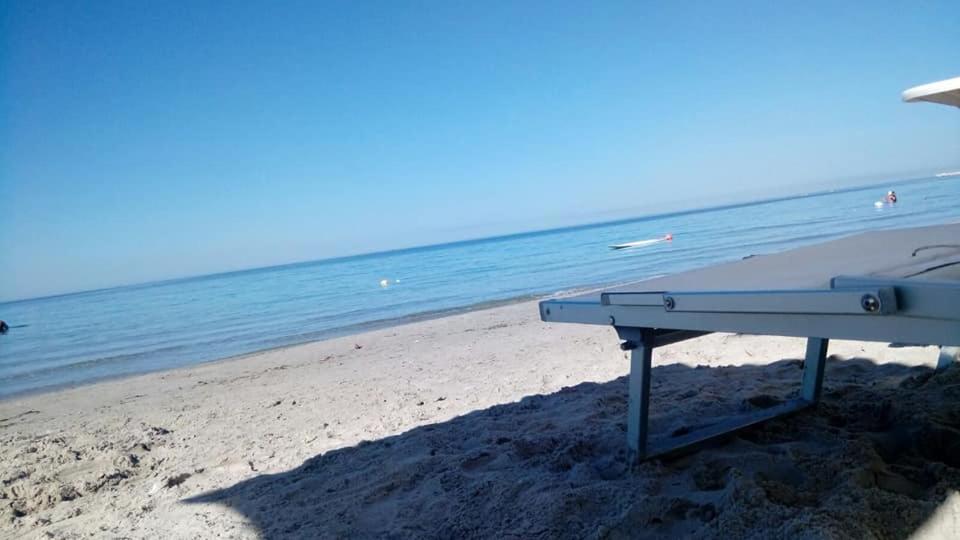 a picnic table on a beach with the ocean at Residence San Vito in Mazara del Vallo