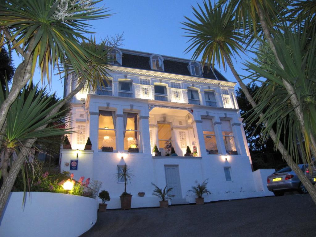 a white house with palm trees in front of it at The Shirley in Torquay