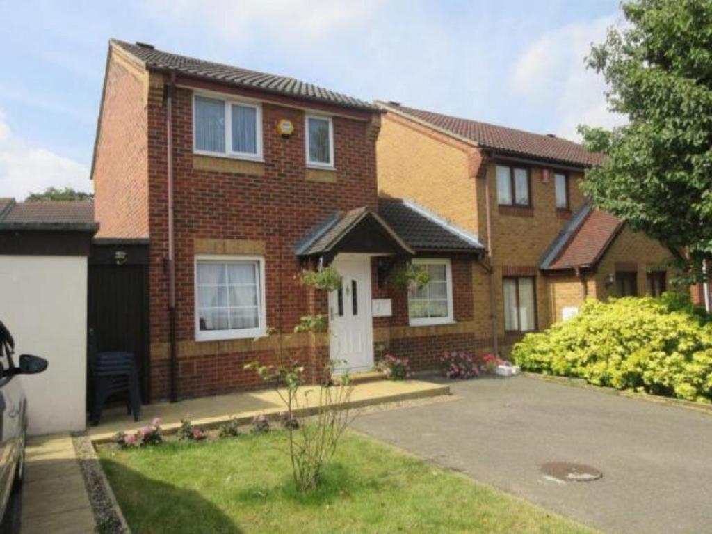 a brick house with a white door and a driveway at Apartment & Rooms in London in Croydon