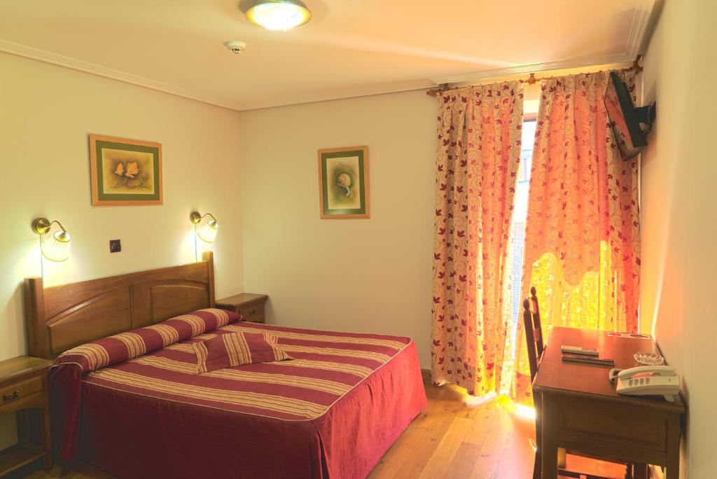 a bedroom with a bed and a nightstand at Hotel Jacobeo in Belorado