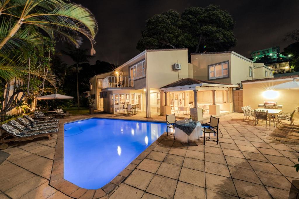 una piscina di fronte a una casa di notte di Forest Manor Boutique Guesthouse a Durban