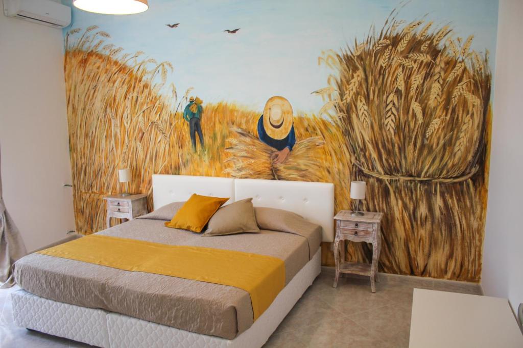 Schlafzimmer mit einem Bett mit Wandgemälde in der Unterkunft Belice rooms in Salemi