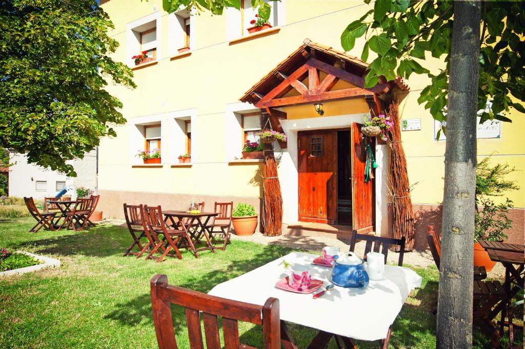 uma mesa e cadeiras num quintal com um edifício em Apartamentos El Pajar del Abuelo em Peralejos de las Truchas