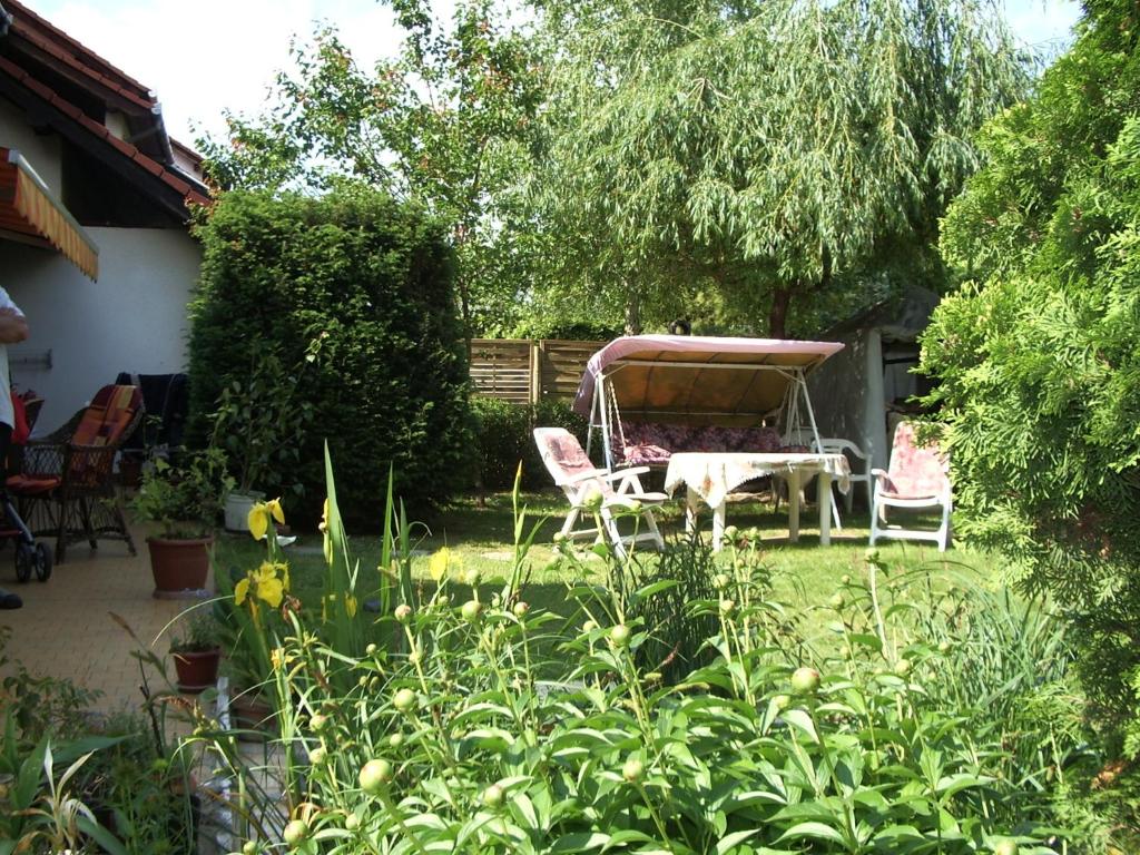 ogród z 2 krzesłami i stołem na dziedzińcu w obiekcie Apartmanház Gabriella w mieście Harkány