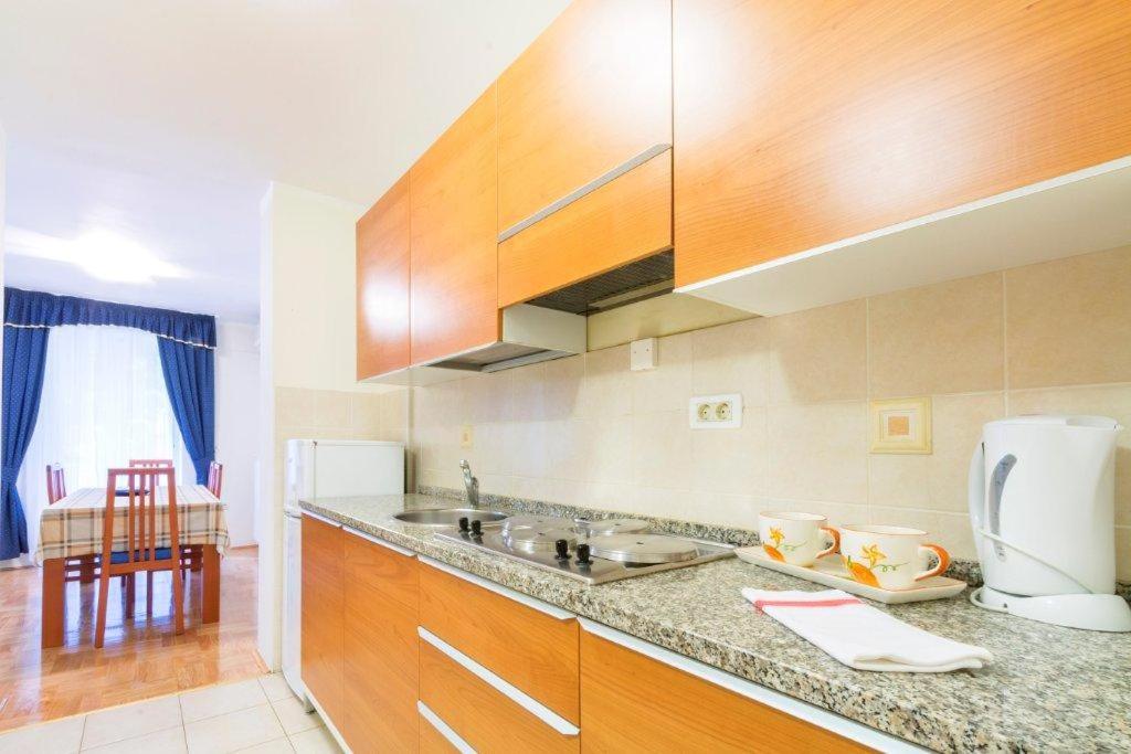 a kitchen with wooden cabinets and a counter top at Sfinga Verudela V in Pula